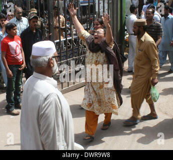 Réagir à l'hôpital en deuil après l'assassinat de leurs proches lors d'un affrontement entre deux bandes rivales dans le marché de Lyari Jhat Pat, à Karachi le Mercredi, Mars 12, 2014. Batailles de rue entre deux gangs rivaux armés de grenades et de mitrailleuses ont tué au moins 16 personnes, dont quatre femmes, ont déclaré. L'affrontement, qui selon la police a également blessé 39 personnes, principalement des écoliers, a été la pire flambée de violence liée aux criminels d'affliger la ville troublée au cours des derniers mois. Banque D'Images