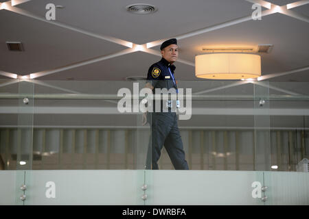 Putrajaya, MYS. 12Th Mar, 2013. Membre de la Malaysian Airlines est la police garde à un hôtel à Putrajaya, en dehors de Kuala Lumpur, Malaisie, le mercredi 12 mars 2014. C'est aujourd'hui le cinquième jour de la disparition du vol MH370 : qui le Jetliner peut-être tenté de revenir en arrière avant qu'elle a disparu du radar, mais il n'y a pas de preuve qu'il a atteint le détroit de Malacca, Malaisie, chef de l'armée de l'air a déclaré mercredi, le refus déclaré remarques qu'il a dit le contraire. La déclaration suggère une confusion continue où le Boeing 777 pourrait avoir fini, plus de quatre jours après il disapp Banque D'Images