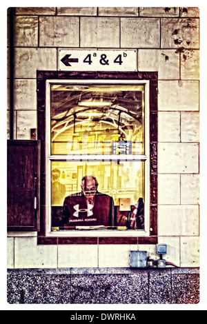 A la lecture de journal dans une salle d'attente à la gare centrale de Cardiff. Mars 2014 Banque D'Images