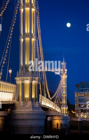 Albert Pont sur la Tamise à Londres, ornés de lumières et la lune brille à travers le ciel de nuit derrière. Banque D'Images