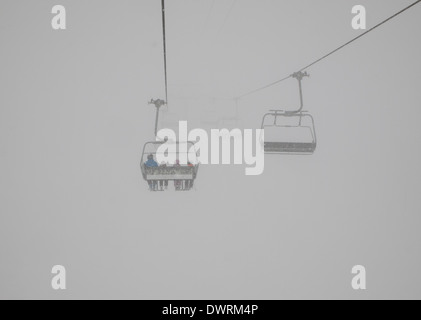 D'un télésiège avec la disparition des skieurs dans le brouillard Banque D'Images