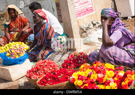 Le Sud de l'Inde du Sud Tamil Nadu Madurai marché aux fleurs femelles femmes chers vendeur vend des paniers de fleurs de roses & Saree sari rouge Banque D'Images