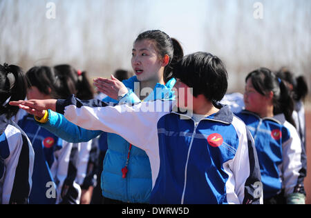 Shenyang. 13Th Mar, 2014. Professeur bénévole Jian Zhu (L), un jeune étudiant de l'université de Shenyang, Le sport donne une classe PE aux étudiants à Xiaochengzi neuf ans d'école du comté de Kangping à Shenyang, capitale de la province du Liaoning en Chine du nord-est. Quelque 90 élèves de niveau junior de Shenyang University Sport ont été envoyés aux écoles primaires et secondaires dans les surburbs tearchers de Shenyang comme bénévole pour la moitié d'une année. © Zhang Wenkui/Xinhua/Alamy Live News Banque D'Images