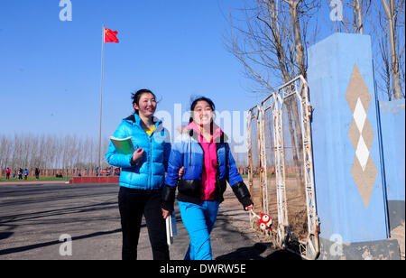 Shenyang. 13Th Mar, 2014. Professeur bénévole Jian Zhu (L) et Wang Ninghui, tant les élèves du cycle de l'université de Shenyang Sport, revenir à pied à son bureau après la classe Xiaochengzi à neuf ans d'école du comté de Kangping à Shenyang, capitale de la province du Liaoning en Chine du nord-est. Quelque 90 élèves de niveau junior de Shenyang University Sport ont été envoyés aux écoles primaires et secondaires dans les surburbs tearchers de Shenyang comme bénévole pour la moitié d'une année. © Zhang Wenkui/Xinhua/Alamy Live News Banque D'Images