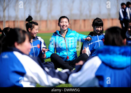 Shenyang. 13Th Mar, 2014. Professeur bénévole Jian Zhu, un jeune étudiant de l'université de Shenyang, Le sport donne une classe PE aux étudiants à Xiaochengzi neuf ans d'école du comté de Kangping à Shenyang, capitale de la province du Liaoning en Chine du nord-est. Quelque 90 élèves de niveau junior de Shenyang University Sport ont été envoyés aux écoles primaires et secondaires dans les surburbs tearchers de Shenyang comme bénévole pour la moitié d'une année. © Zhang Wenkui/Xinhua/Alamy Live News Banque D'Images