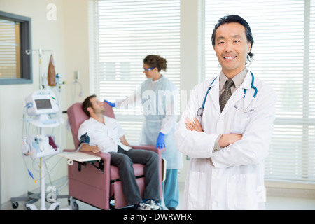 Happy doctor with patient en cours d'examen par la machine de pulsation Banque D'Images