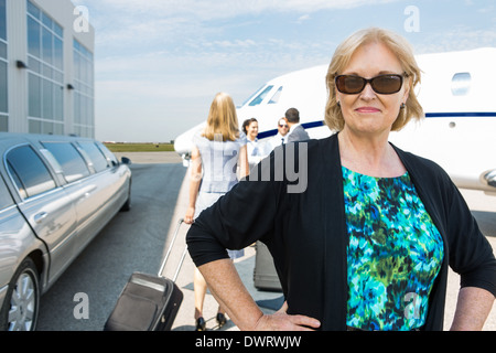 Confident businesswoman contre private jet Banque D'Images