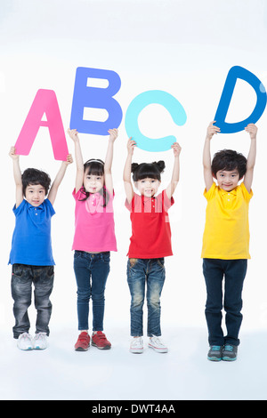 Kids holding lettres alphabet en l'air Banque D'Images