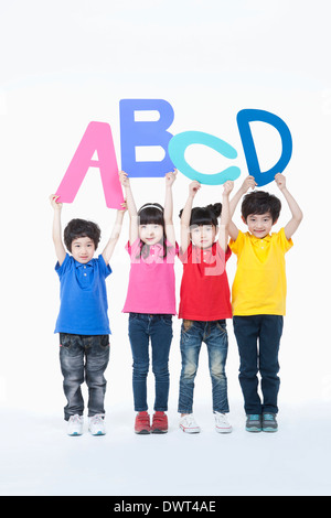 Kids holding lettres alphabet en l'air Banque D'Images