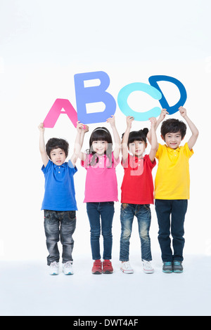 Kids holding lettres alphabet en l'air Banque D'Images