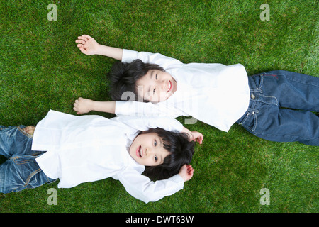 Un garçon et une fille lying on grass Banque D'Images