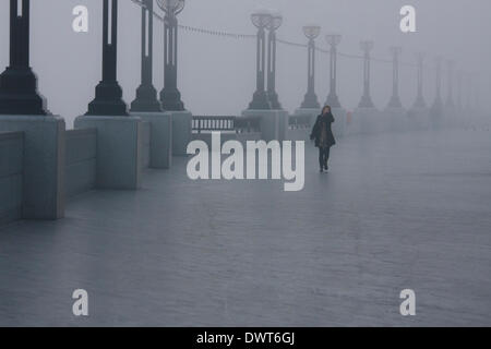 Londres, Royaume-Uni. Le 13 mars 2014. Une femme se rend au travail comme des couvertures de brouillard la ville avant le jour s'illumine. Crédit : Paul Davey/Alamy Live News Banque D'Images