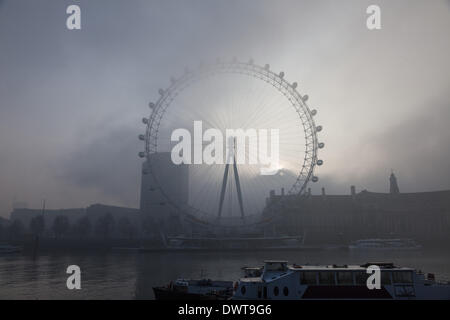 Londres, Royaume-Uni, le 13 mars, 2014. Londres commence le jour enveloppée dans une couverture de brouillard. Le soleil se lève au-dessus du County Hall, Westminster, et derrière le London Eye Crédit : Steve Bright/Alamy Live News Banque D'Images