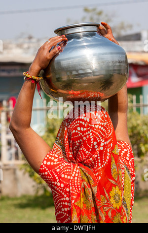 Abhaneri, Rajasthan, Inde. Femme ajuste Pot d'eau sur le dessus de sa tête avant de rentrer à la maison. Banque D'Images