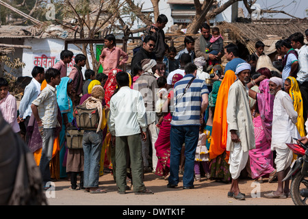 Abnaheri, Rajasthan, Inde. Village foule rassemblée autour de deux touristes. Banque D'Images