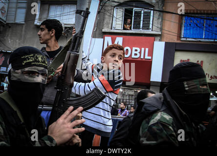 Gaza, Territoires palestiniens. Mar 11, 2014. Un garçon palestinien ressemble aux funérailles du militant du Jihad islamique, qui a été tué avec deux autres militants dans une frappe aérienne israélienne à Khan Younis, au sud de la bande de Gaza, 11 mars 2014. Une frappe aérienne israélienne a tué trois militants palestiniens à Khan Younis au sud de la bande de Gaza-ville. L'armée israélienne aurait dit un des avions israéliens militants du Jihad islamique ciblée qui avait tiré un obus de mortier à ses forces. Credit : Sameh Rahmi/NurPhoto ZUMAPRESS.com/Alamy/Live News Banque D'Images