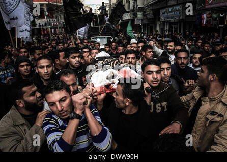 Gaza, Territoires palestiniens. Mar 11, 2014. Deuil palestiniens portent le corps d'un militant du Jihad islamique lors de ses funérailles à Khan Younis, au sud de la bande de Gaza, 11 mars 2014. Une frappe aérienne israélienne a tué trois militants palestiniens à Khan Younis au sud de la bande de Gaza-ville. L'armée israélienne aurait dit un des avions israéliens militants du Jihad islamique ciblée qui avait tiré un obus de mortier à ses forces. Credit : Sameh Rahmi/NurPhoto ZUMAPRESS.com/Alamy/Live News Banque D'Images