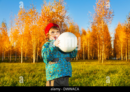 Trois ans rire petit garçon blanc jeter volley-ball ball autumn park Banque D'Images