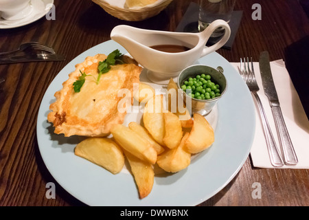 Pub Anglais traditionnel dîner steak pie de pois et de croustilles de pommes de terre et de la sauce Banque D'Images