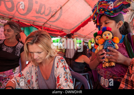 Un Guatamalan fille vend des poupées de chiffon traditionnel le week-end à Juayua feria alimentaire sur les routes de la flores en El Salvador Banque D'Images