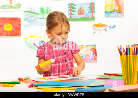 Clever 4 ans girl holding colle par le tableau de l'art à l'école maternelle de leçon Banque D'Images