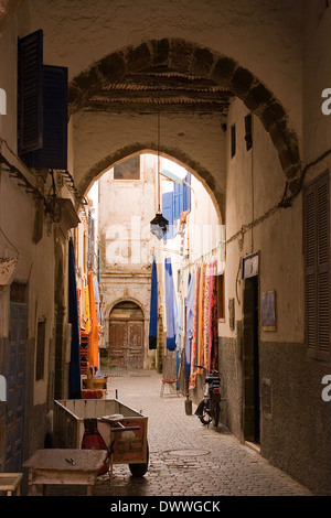 Draps colorés suspendus à l'extérieur dans une rue de Médina à Essaouira, Maroc Banque D'Images