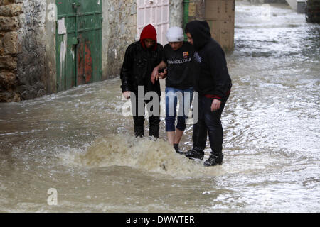 Hébron, en Cisjordanie, en territoire palestinien. 13Th Mar, 2014. Les palestiniens à pied à travers l'inondation des rues dans la vieille ville de Hébron, dans le sud de la Cisjordanie, 13 mars 2014. L'Autorité palestinienne et Israël tout entier est sous pluies versant et des températures froides pour les trois derniers jours pour compenser l'une des plus sèches de janvier et Februarys dans beaucoup d'années de crédit : Mamoun Wazwaz APA/Images/ZUMAPRESS.com/Alamy Live News Banque D'Images
