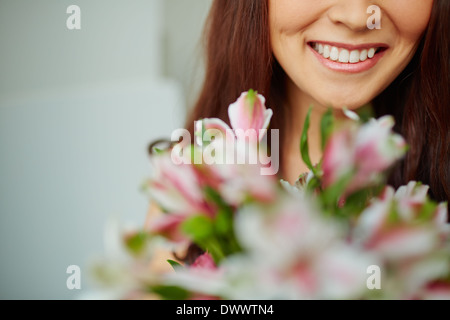 Portrait de femme sourire à pleines dents et de fleurs Banque D'Images