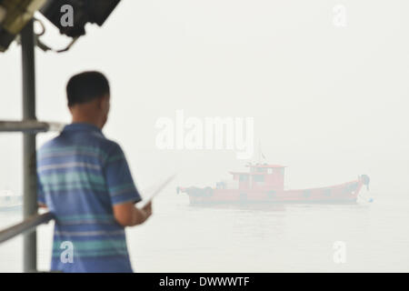 Selangor, Malaisie. 14 mars, 2014. Un touriste attend à bord d'un bateau à Port Klang, Malaisie, le 14 mars 2014. Les écoles sont fermées le vendredi à cause de l'insalubrité de l'air. Les polluants de l'air index (API) de Port Klang, située à l'ouest de la capitale, Kuala Lumpur, a frappé le vendredi niveau malsain, selon le site web du ministère de l'environnement de la Malaisie. (Xinhua/Chong Voon Chung) (lmz) Banque D'Images