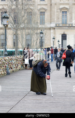 Une vieille dame qui mendiaient dans les rues de Paris France Banque D'Images