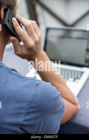 Man using laptop and mobile phone Banque D'Images