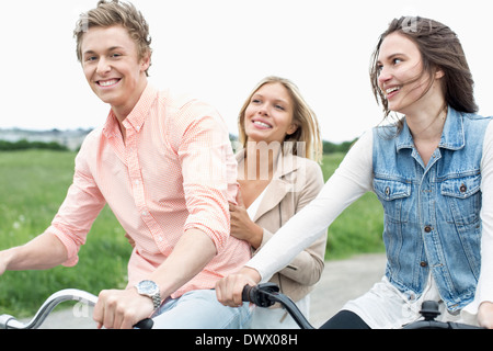 Portrait d'homme heureux appréciant en vélo avec des amis à la campagne Banque D'Images