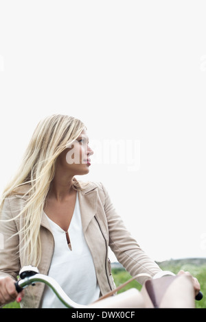 Jeune femme avec location à l'extérieur contre ciel clair Banque D'Images