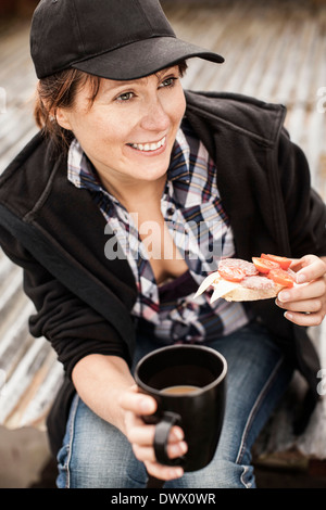 Happy female farmer le petit-déjeuner à farm Banque D'Images