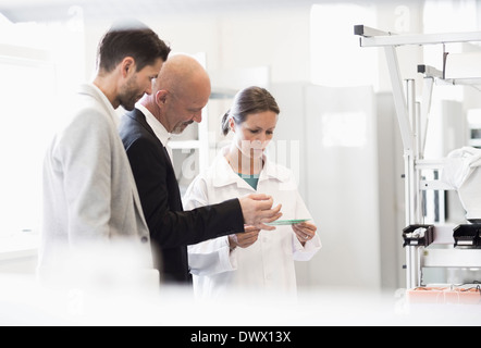 Ingénieur d'affaires et des femmes discuter de machine dans l'usine de fabrication Banque D'Images