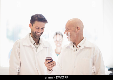 Heureux homme ingénieurs utilisant mobile phone in manufacturing plant Banque D'Images