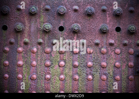 Détail d'une grungy, décolorées, plaque rouge sur le côté d'une vieille machine à vapeur de rouille en Angleterre, Royaume-Uni Banque D'Images