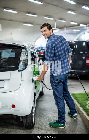 Portrait de jeune homme à la voiture électrique de charge station de gaz Banque D'Images