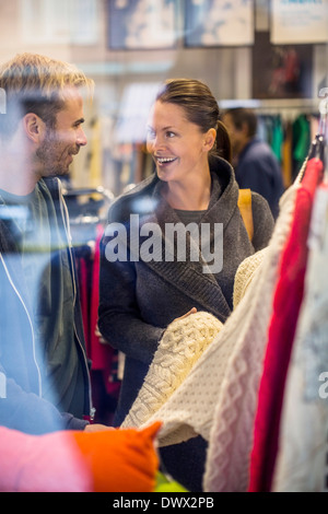 Happy friends shopping pour les chandails in clothing store Banque D'Images