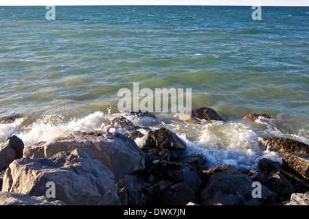 Le lac Huron éclaboussures des vagues sur les rochers jusqu'à Rogers City, Michigan Banque D'Images