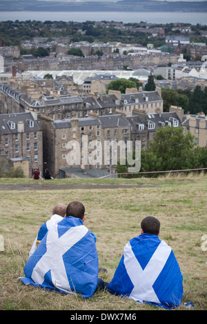 Trois jeunes garçons drapés dans des drapeaux écossais assis sur Calton Hill, à Édimbourg, au cours d'un pro-indépendance mars Banque D'Images