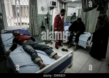 Gaza, Territoires palestiniens. Feb 17, 2012. Les médecins palestiniens ont tendance à l'homme qu'ils ont dit a été blessé dans un raid aérien israélien, dans un hôpital de Rafah dans le sud de la bande de Gaza le 13 mars 2014. Un cessez-le-feu négocié par l'Egypte le jeudi pour mettre fin à une flambée de roquettes à partir de Gaza sur des villes israéliennes et des raids aériens israéliens dans l'enclave palestinienne, le groupe militant du Jihad islamique a dit. © Abed Rahim Khatib/NurPhoto ZUMAPRESS.com/Alamy/Live News Banque D'Images