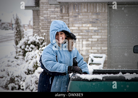 Joyeux enfant jouant joyeusement dans la neige portant des gros manteau chaud Banque D'Images