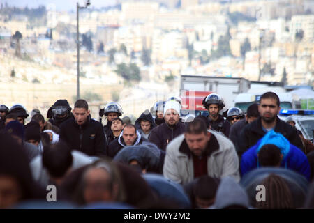 Jérusalem, Jérusalem, territoire palestinien. 14Th Mar, 2014. Prier les musulmans palestiniens à l'extérieur de la vieille ville de Jérusalem comme la police israélienne les bloquer de prier dans la mosquée Al-Aqsa de la ville, dans le quartier de Ras Al-Amoud à Jérusalem le 14 mars 2014. Israël restreint l'entrée pour la prière du vendredi à la mosquée al-Aqsa pour éviter d'éventuels affrontements Crédit : Saeed Qaq/APA Images/ZUMAPRESS.com/Alamy Live News Banque D'Images