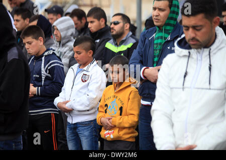 Jérusalem, Jérusalem, territoire palestinien. 14Th Mar, 2014. Prier les musulmans palestiniens à l'extérieur de la vieille ville de Jérusalem comme la police israélienne les bloquer de prier dans la mosquée Al-Aqsa de la ville, dans le quartier de Ras Al-Amoud à Jérusalem le 14 mars 2014. Israël restreint l'entrée pour la prière du vendredi à la mosquée al-Aqsa pour éviter d'éventuels affrontements Crédit : Saeed Qaq/APA Images/ZUMAPRESS.com/Alamy Live News Banque D'Images