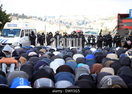Jérusalem, Jérusalem, territoire palestinien. 14Th Mar, 2014. Prier les musulmans palestiniens à l'extérieur de la vieille ville de Jérusalem comme la police israélienne les bloquer de prier dans la mosquée Al-Aqsa de la ville, dans le quartier de Ras Al-Amoud à Jérusalem le 14 mars 2014. Israël restreint l'entrée pour la prière du vendredi à la mosquée al-Aqsa pour éviter d'éventuels affrontements Crédit : Saeed Qaq/APA Images/ZUMAPRESS.com/Alamy Live News Banque D'Images