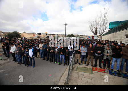 Jérusalem, Jérusalem, territoire palestinien. 14Th Mar, 2014. Prier les musulmans palestiniens à l'extérieur de la vieille ville de Jérusalem comme la police israélienne les bloquer de prier dans la mosquée Al-Aqsa de la ville, dans le quartier de Ras Al-Amoud à Jérusalem le 14 mars 2014. Israël restreint l'entrée pour la prière du vendredi à la mosquée al-Aqsa pour éviter d'éventuels affrontements Crédit : Saeed Qaq/APA Images/ZUMAPRESS.com/Alamy Live News Banque D'Images