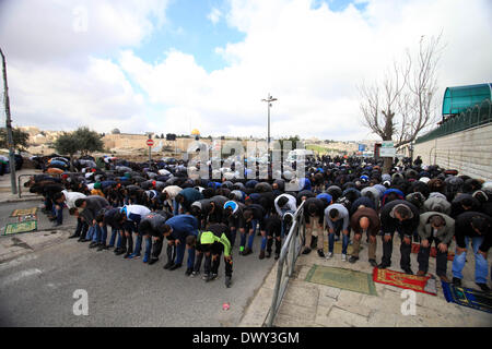 Jérusalem, Jérusalem, territoire palestinien. 14Th Mar, 2014. Prier les musulmans palestiniens à l'extérieur de la vieille ville de Jérusalem comme la police israélienne les bloquer de prier dans la mosquée Al-Aqsa de la ville, dans le quartier de Ras Al-Amoud à Jérusalem le 14 mars 2014. Israël restreint l'entrée pour la prière du vendredi à la mosquée al-Aqsa pour éviter d'éventuels affrontements Crédit : Saeed Qaq/APA Images/ZUMAPRESS.com/Alamy Live News Banque D'Images