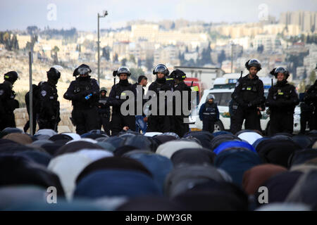 Jérusalem, Jérusalem, territoire palestinien. 14Th Mar, 2014. Prier les musulmans palestiniens à l'extérieur de la vieille ville de Jérusalem comme la police israélienne les bloquer de prier dans la mosquée Al-Aqsa de la ville, dans le quartier de Ras Al-Amoud à Jérusalem le 14 mars 2014. Israël restreint l'entrée pour la prière du vendredi à la mosquée al-Aqsa pour éviter d'éventuels affrontements Crédit : Saeed Qaq/APA Images/ZUMAPRESS.com/Alamy Live News Banque D'Images
