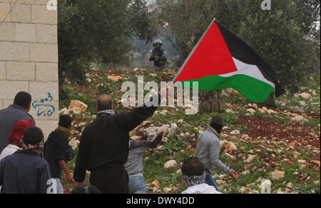 Naplouse, Cisjordanie, territoire palestinien. 14 mars 2014. Un Palestinien est titulaire d'un drapeau national au cours d'une manifestation contre l'expansion des colonies juives de Kufr Qadoom village près de la Rive occidentale, la ville de Naplouse, mars. 14, 2014. Source : Xinhua/Alamy Live News Banque D'Images
